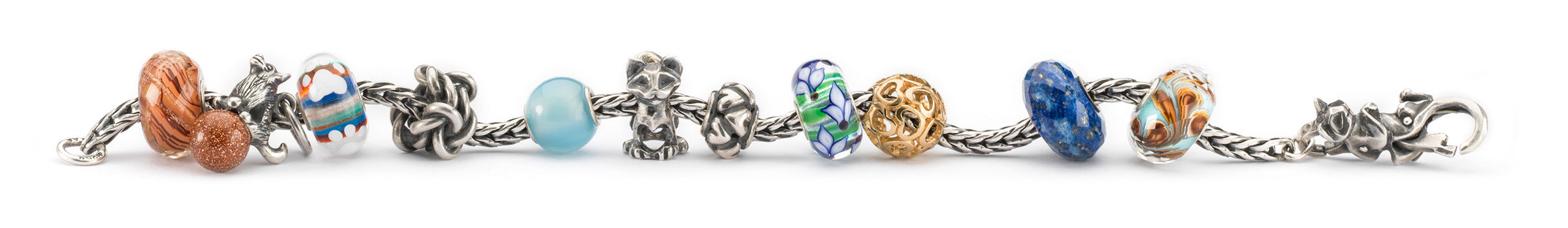 Das Trollbeads-Armband besteht aus einer Mischung aus Beads aus Gold, Silber und Edelsteinen, einem Glasbead mit einem kleinen Pfotenabdruck und Beads mit Katzen und einem Hund, die die geschätzte Bindung und Zuneigung zwischen Haustieren und ihren Besitzern symbolisieren.